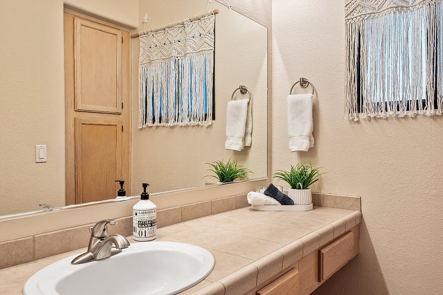 Primary bathroom with large vanity and mirror.