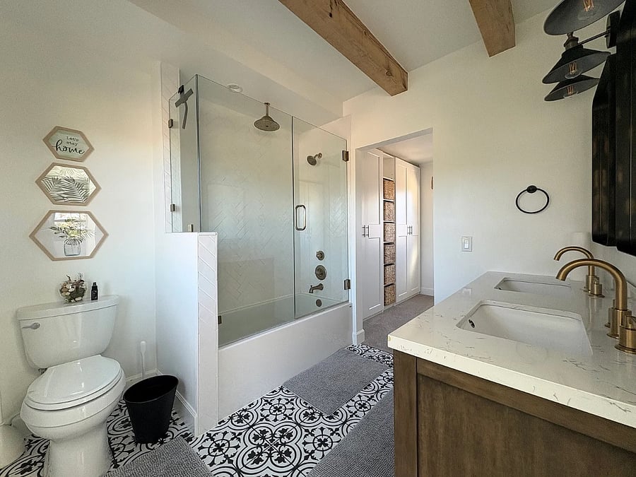 Primary bathroom with rain shower and closet in the background