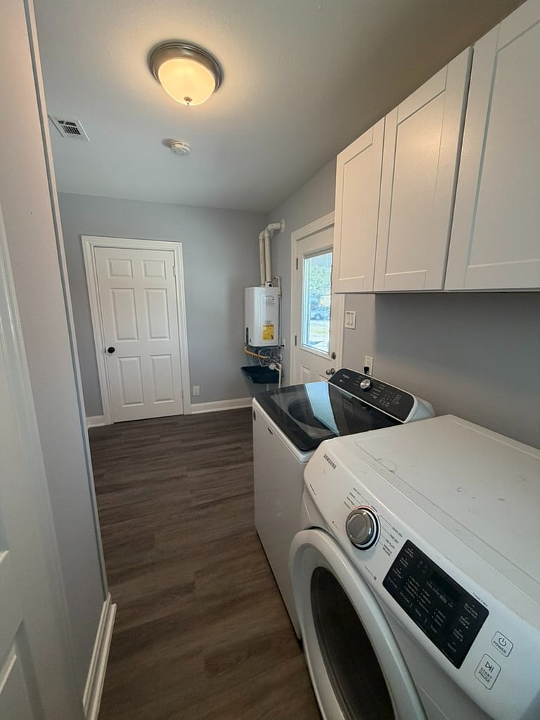 Laundry room with washer and dryer. Vacuum, swiffer, and floor mop located in closet.