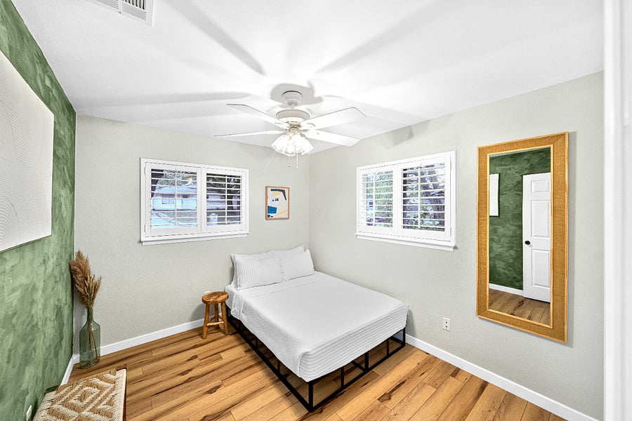 Secondary #2 bedroom wide-angle shot with double bed, full length mirror, woven stool, and estate window shutters.