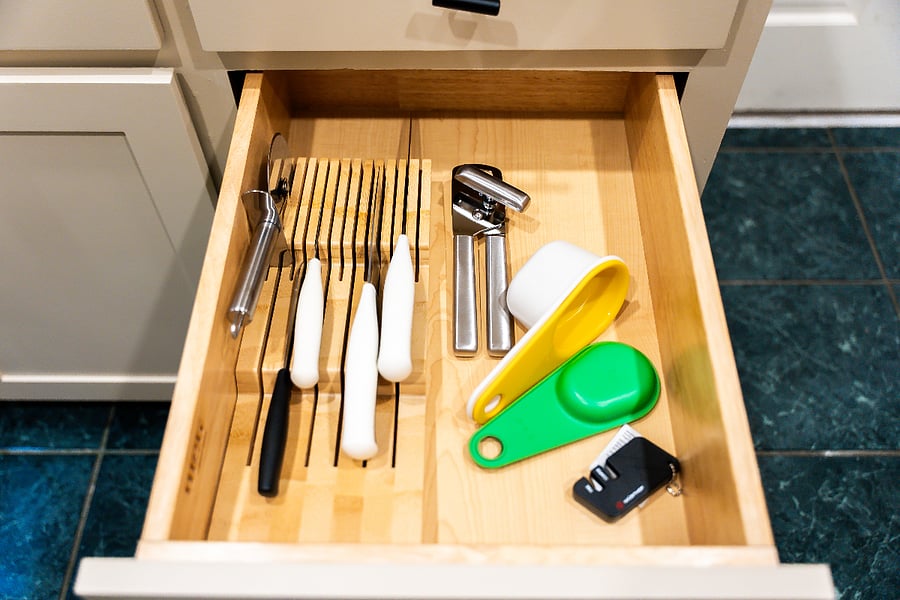 Kitchen drawer with measuring cups, knives, can opener and knife sharpener