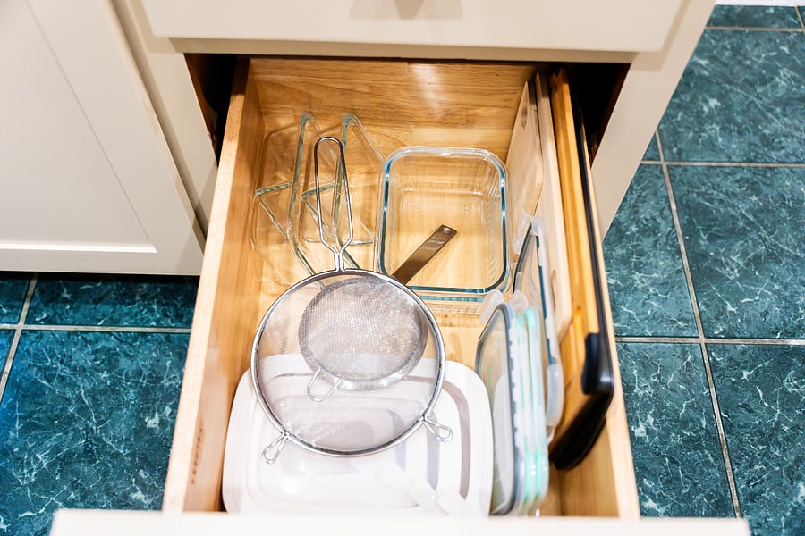 Kitchen cabinet drawer with cutting board, food storage containers and strainer