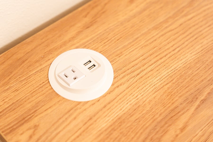 A standing desk with built-in USB connections and outlet.