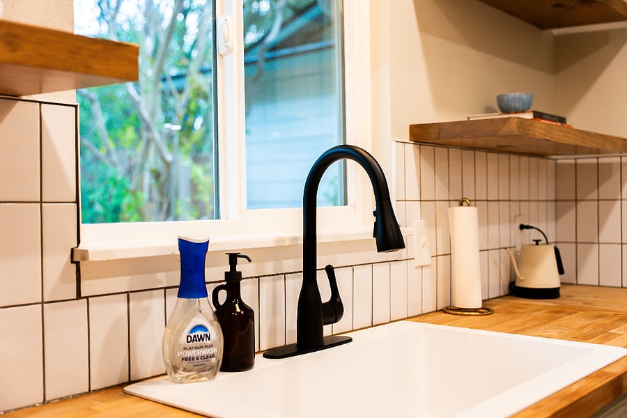 Kitchen counter with deep sink in front of a window facing the backyard