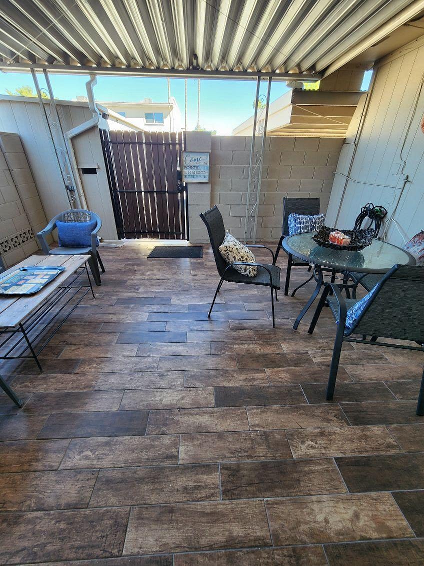 Back covered and tiled patio with patio furniture.