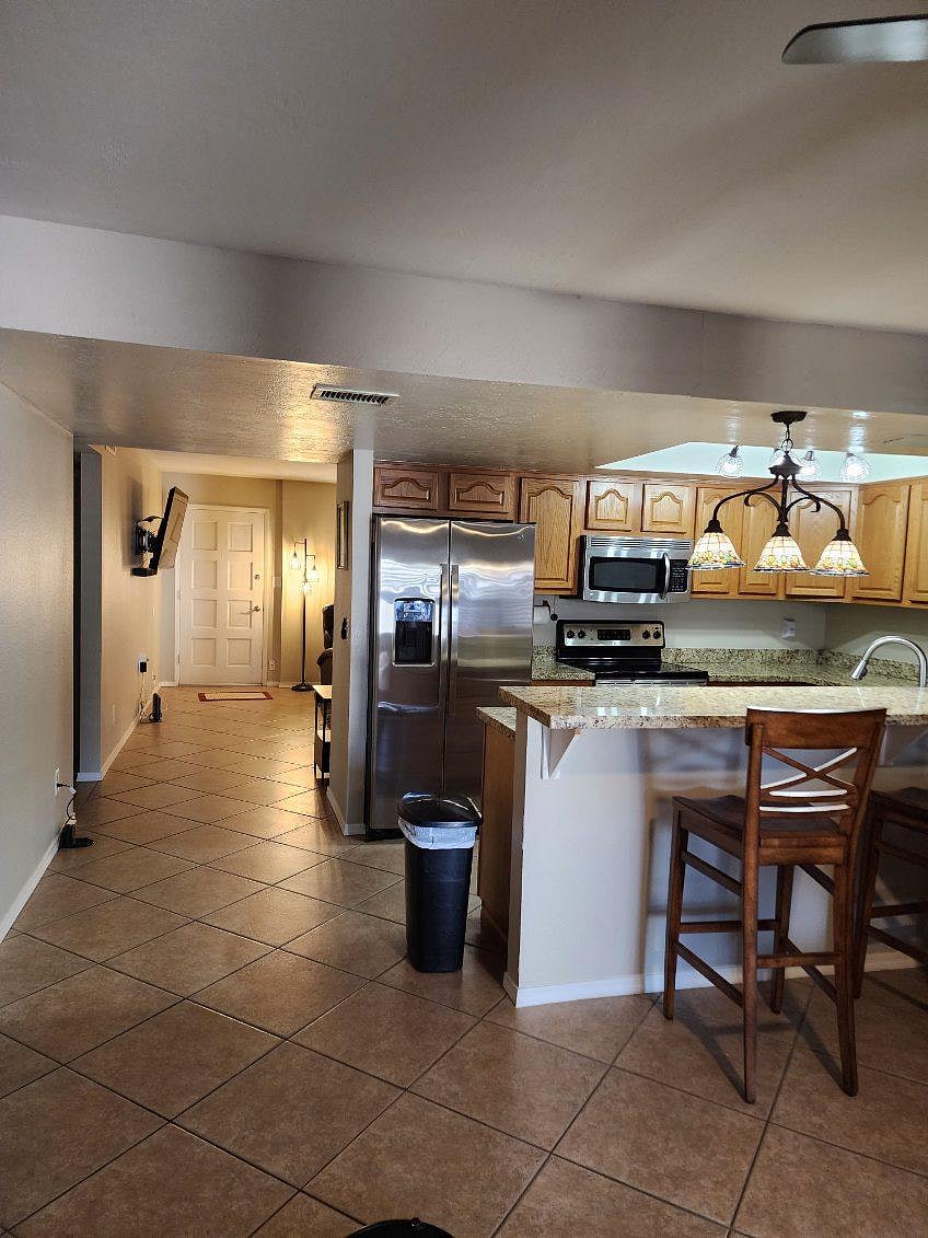 Modern kitchen with granite countertops and breakfast bar.