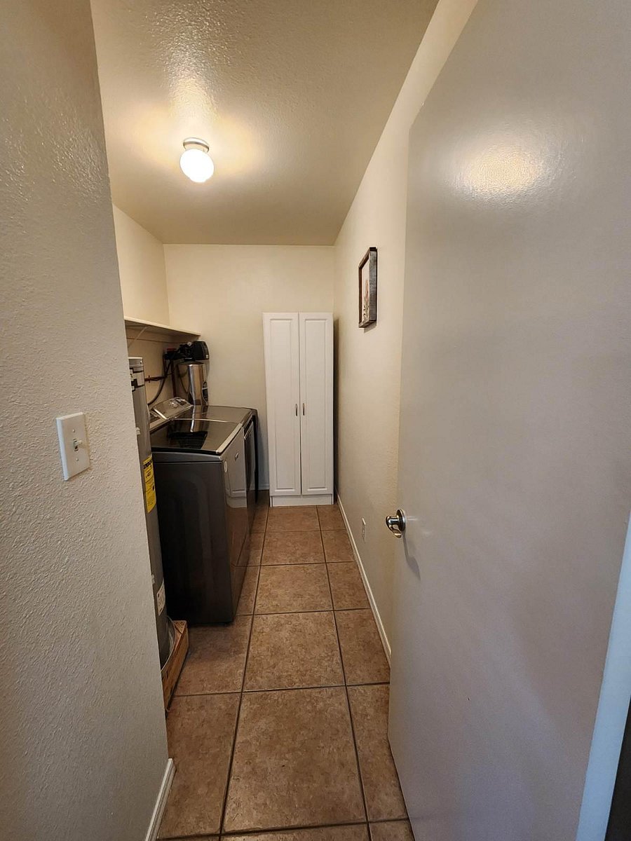 Inside laundry with modern full size washer and dryer.