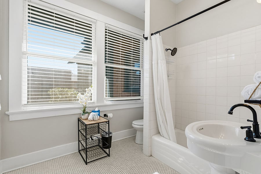 Large windows fill the bathroom with natural light, highlighting its classic character and thoughtful updates.