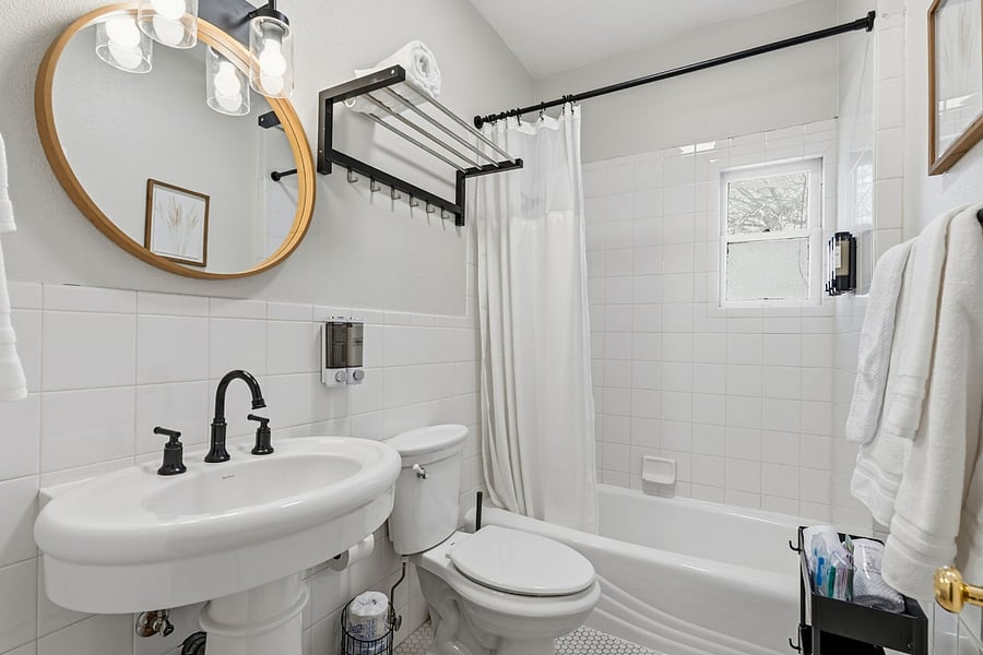 Updated shared bathroom with full tub-shower and classic details, clean and functional