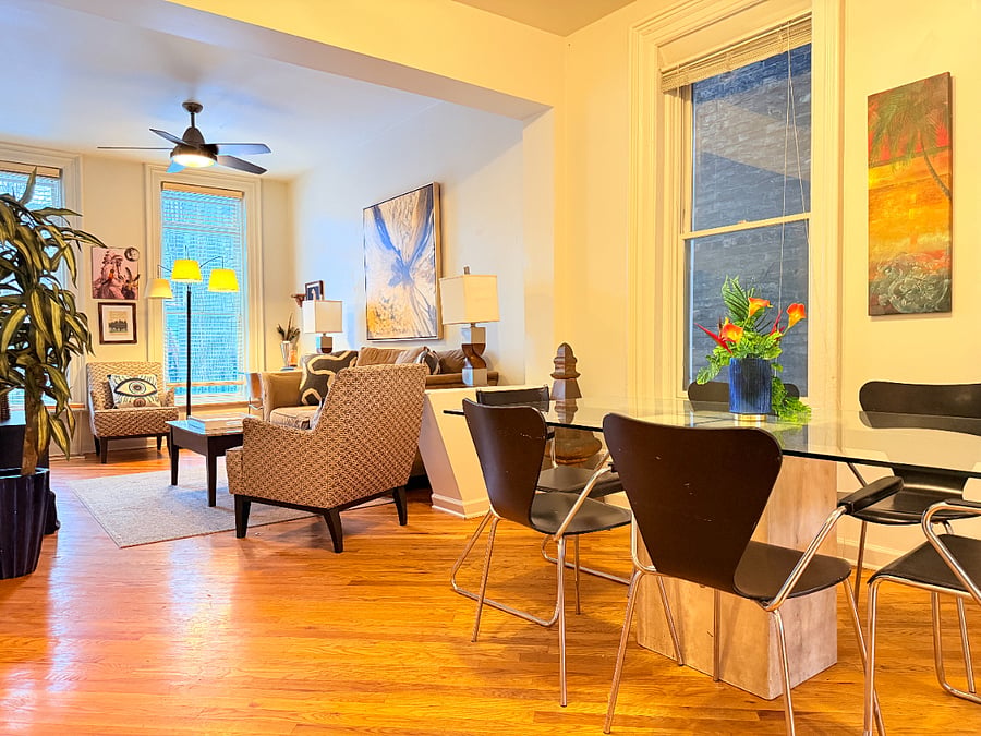 Modern dining area with a glass table and seating for up to 6 guests in an open, bright living space. Perfect for gatherings or enjoying meals together.