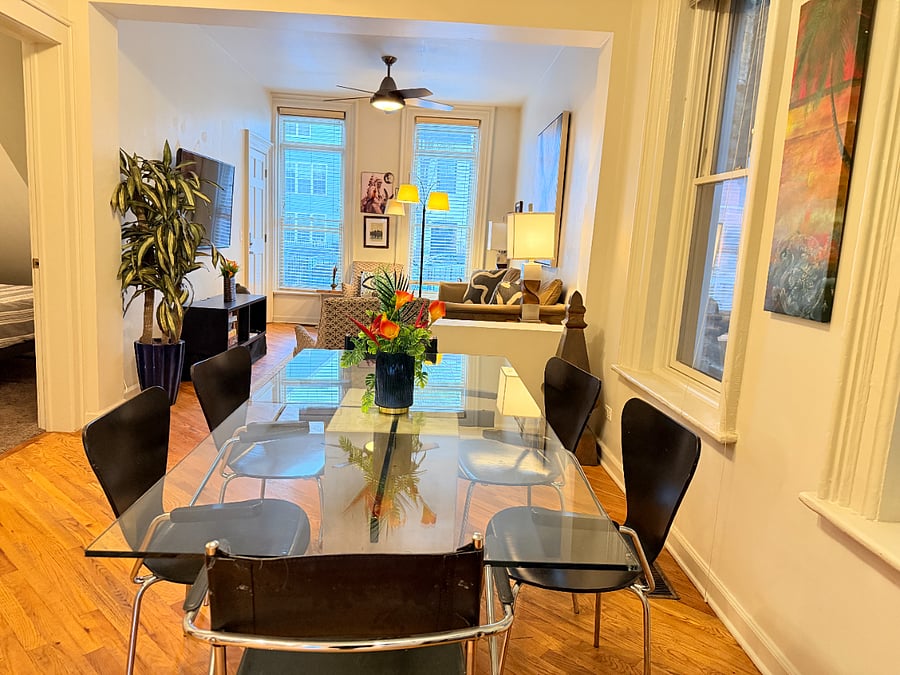 Modern dining area with a glass table and seating for up to 6 guests in an open, bright living space. Perfect for gatherings or enjoying meals together.