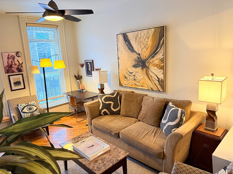 Bright and inviting living room filled with natural light, comfortable seating, stylish dcor, and a dedicated workspace. A perfect spot to relax, unwind, or get some work done.