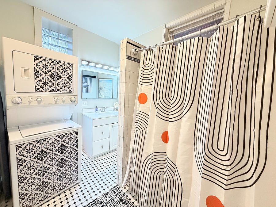 A modern, functional bathroom with a shower and convenient in-unit washer and dryer for added comfort during your stay.