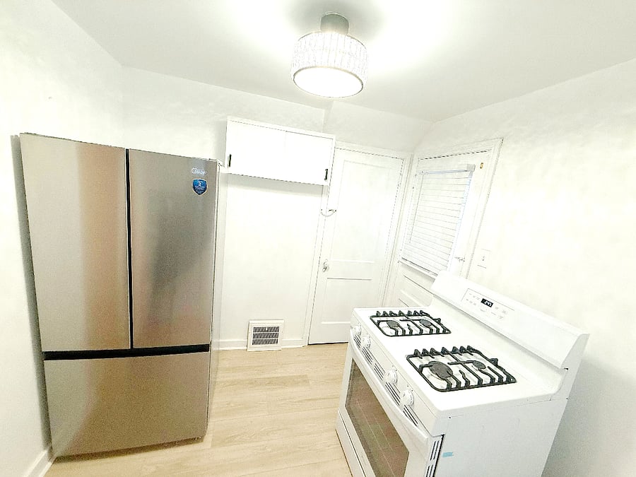 Modern kitchen with a brand new French door refrigerator, stove, microwave, toaster and ample countertop space