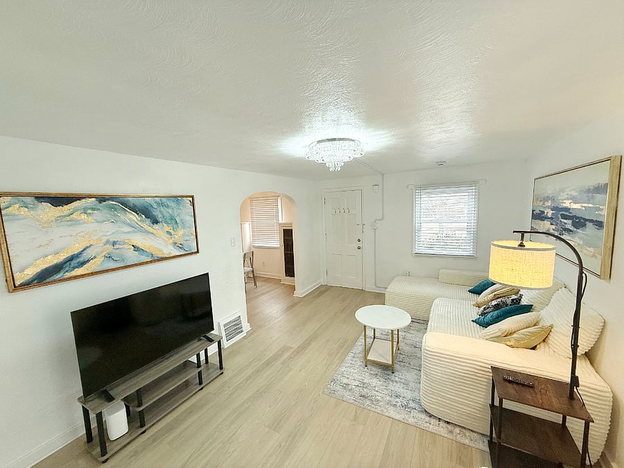 Bright, open living room with a brand new sofa set, TV and modern artwork, creating a clean and relaxing space