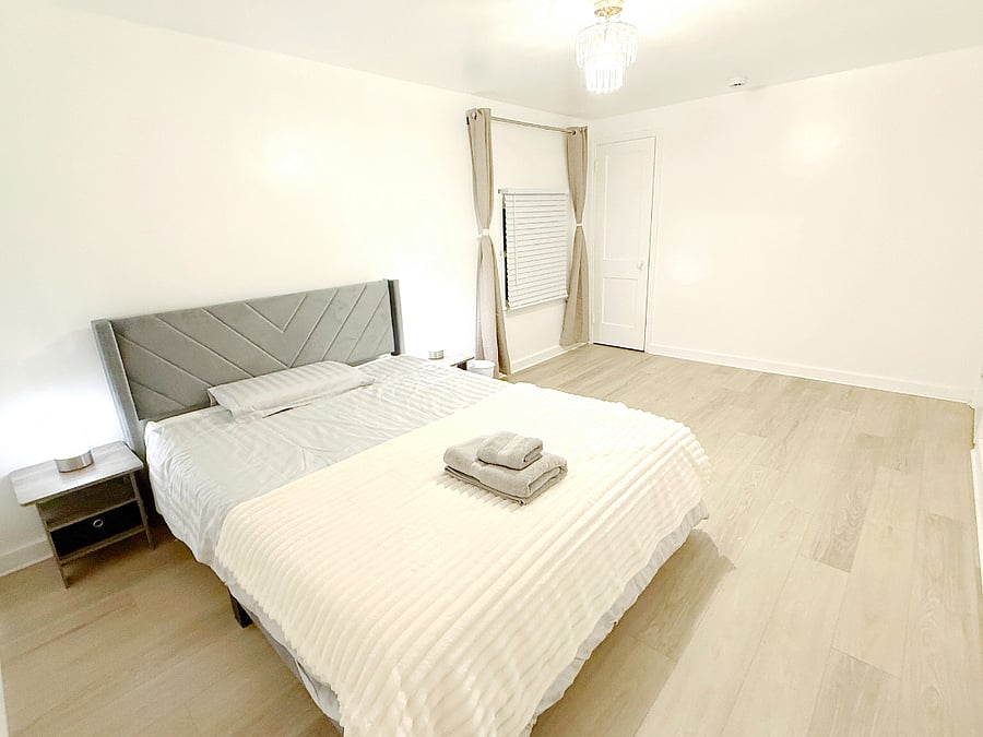 Spacious primary bedroom with a queen bed, built-in wardrobe, and a high-quality memory foam mattress