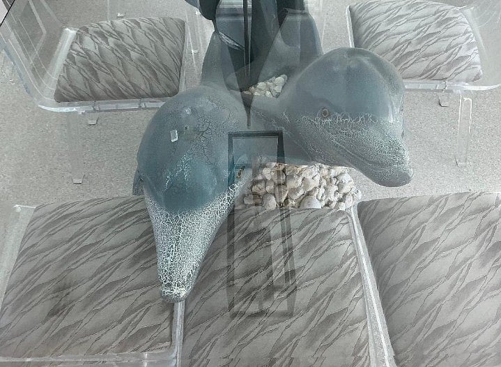 Sculptured dolphin table seating for 8 people, acrylic chairs, and glass top