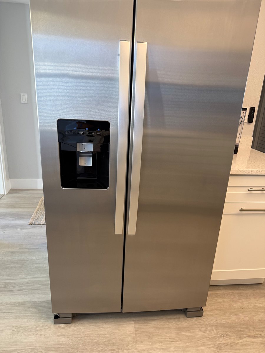 New side-by-side refrigerator and freezer with water and ice dispenser.