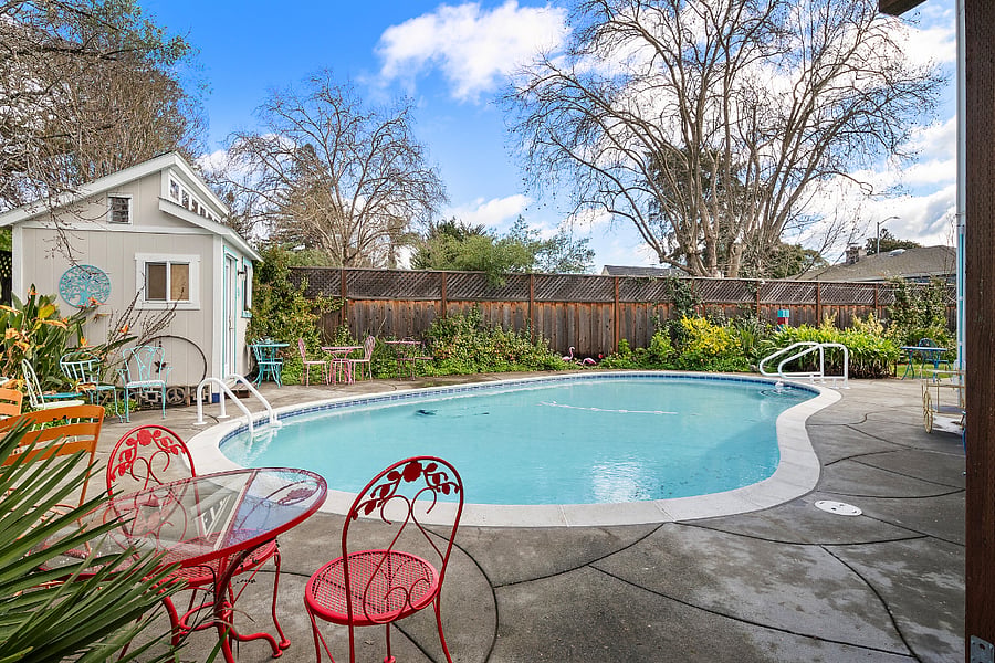 Private deck has view of backyard pool and landscaping.
