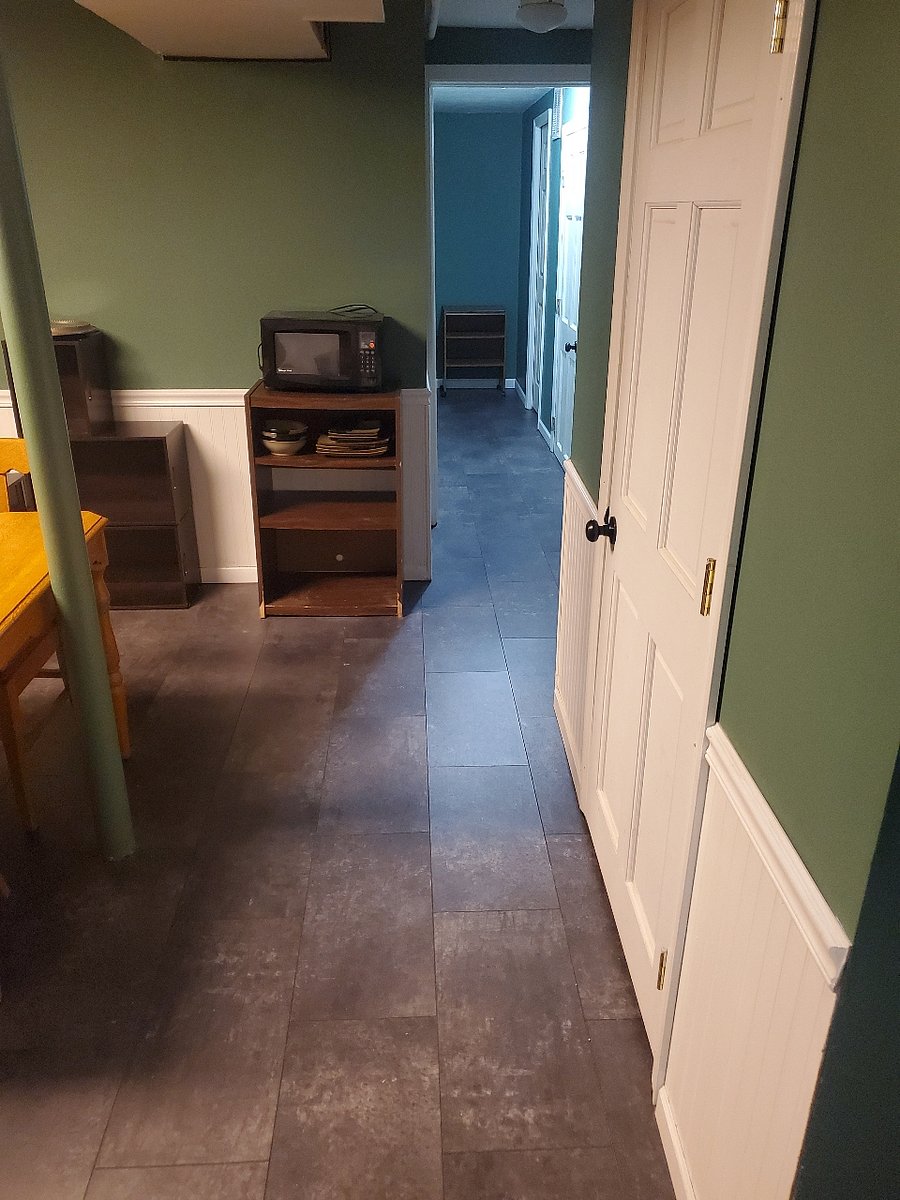 After going down the stairs, you will enter the den. The laundry room is to the right, down the hallway is the bathroom, and at the end of the hallway is your bedroom.