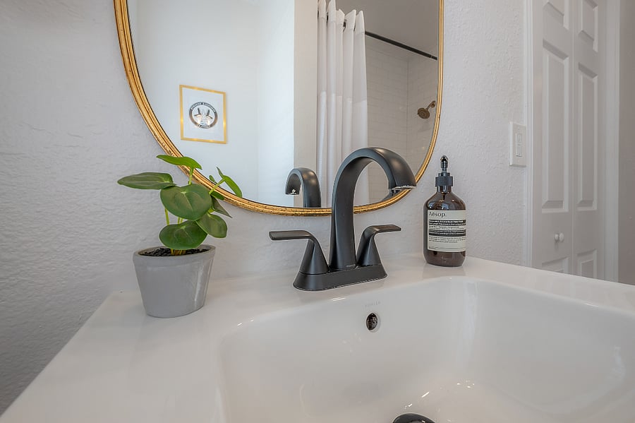 Fully renovated bathroom with tub/shower, pedestal sink, and fully stocked linen closet