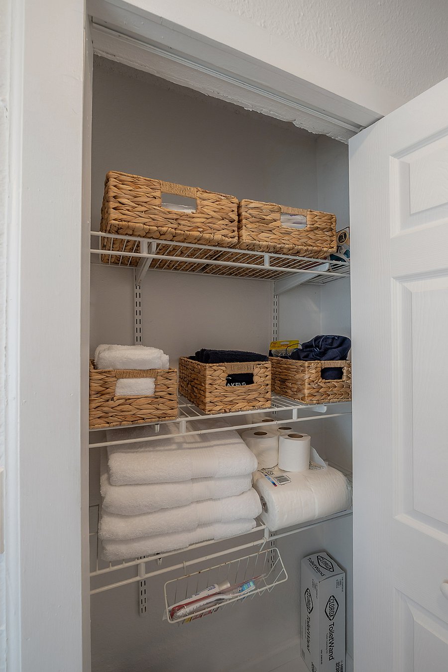 Fully renovated bathroom with tub/shower, pedestal sink, and fully stocked linen closet