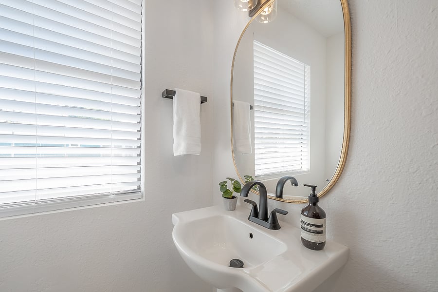 Fully renovated bathroom with tub/shower, pedestal sink, and fully stocked linen closet