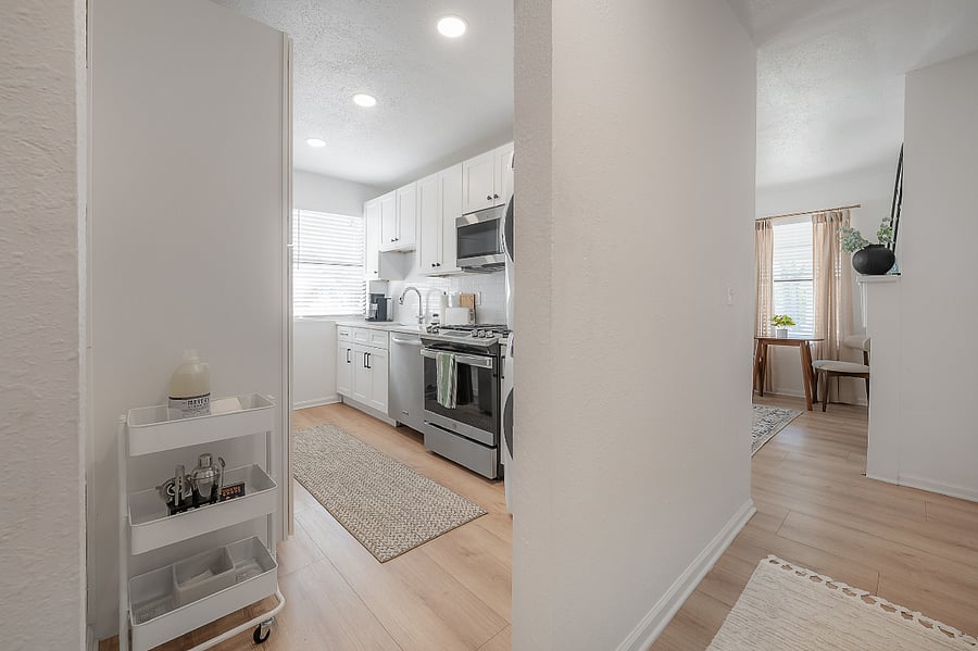 Fully renovated and stocked kitchen with gas range, microwave, dishwasher, refrigerator, and stackable washer and gas dryer