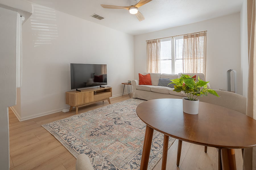 Living room with fireplace, sofa, bistro table with 2 chairs, and Smart TV.
