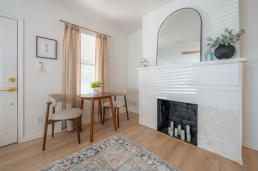 Living room with fireplace, sofa, bistro table with 2 chairs, and Smart TV.