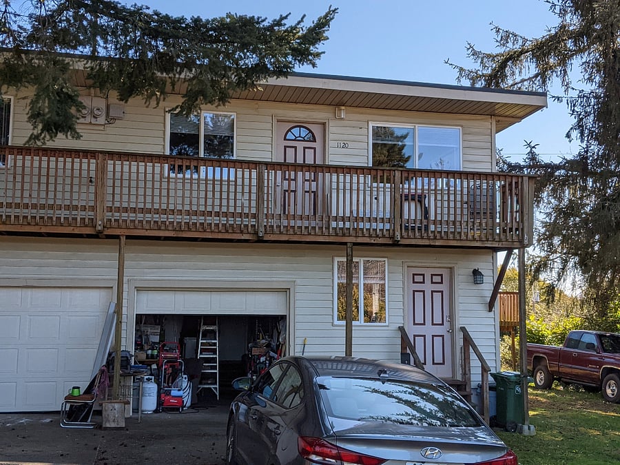Street view of the upstairs apartment and front deck of the property