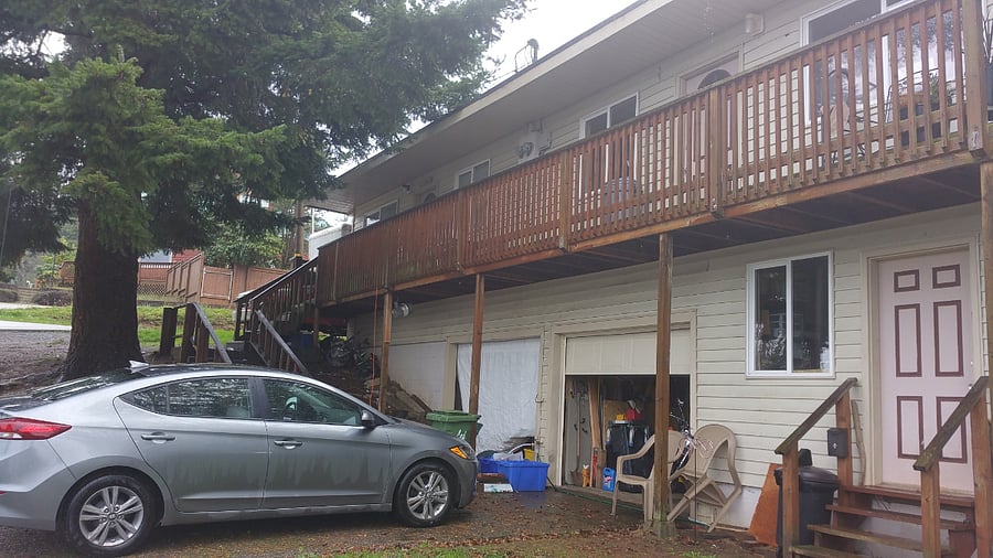 Lower level of the two story structure with a view of the upper deck and it's front entry