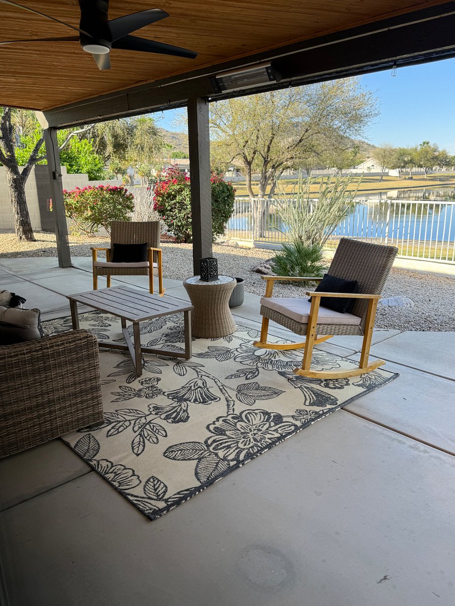 Covered patio seating area with loveseat and 2 rockers- with lakeview