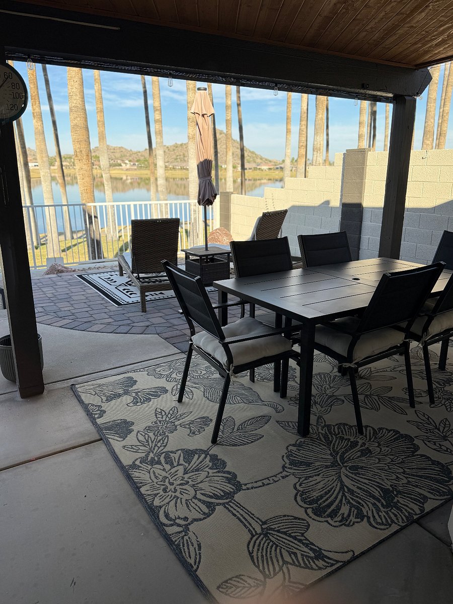 Covered eating area with propane bbq, and chaise loungers with view of lake