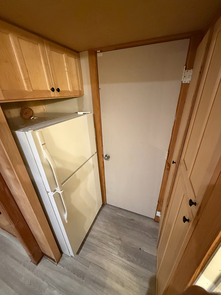 Fridge, door to living area, and pantry on the right
