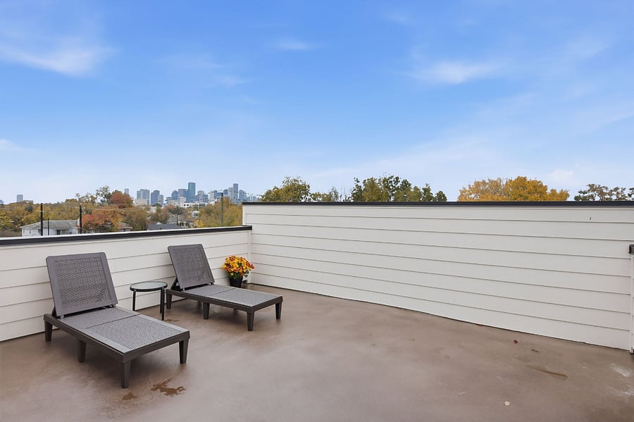 The rooftop deck is furnished with outdoor seating and sun loungers, offering a comfortable space to relax, enjoy fresh air, and unwind above the living areas.
