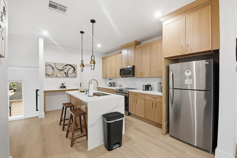 The fully equipped kitchen includes air conditioning and hot water, along with essential cooking basics for everyday meals. Guests have access to a refrigerator, freezer, stove, microwave, dishwasher, toaster, blender, and coffee maker, with coffee provided. The kitchen is stocked with dishes, silverware, baking sheets, and wine glasses. Cleaning products are available for convenience, and the space is equipped with a smoke alarm and fire extinguisher for added safety.