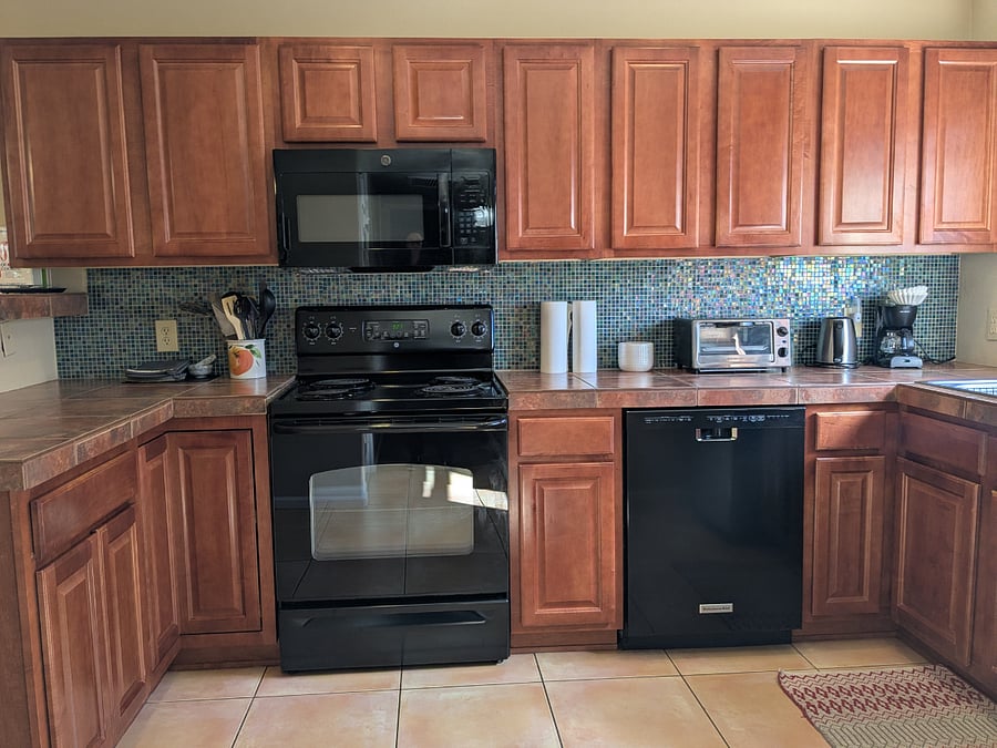The kitchen is fully equipped with a full size refrigerator, oven and range, microwave, dishwasher, toaster oven, kettle, coffee maker, and more.