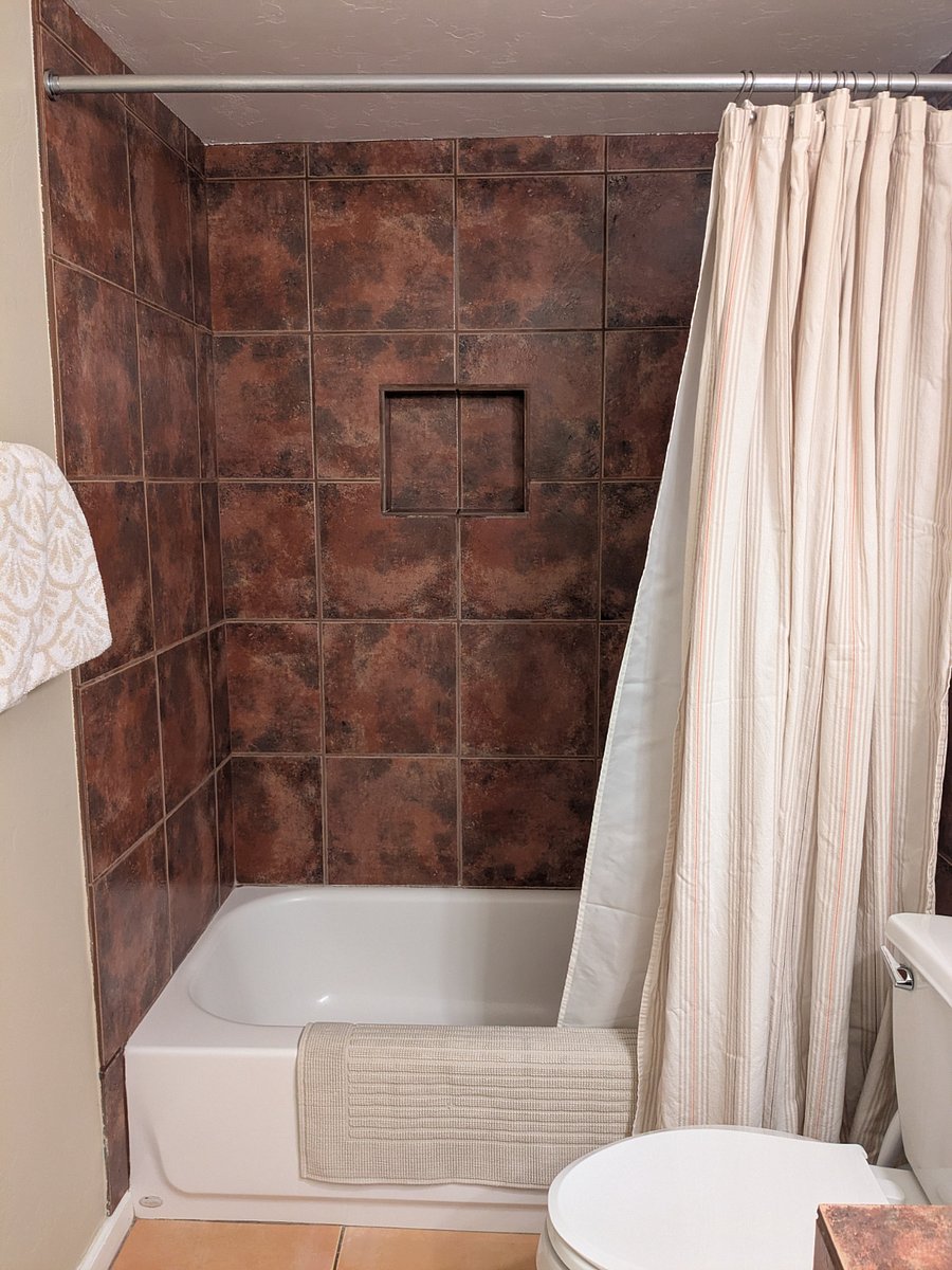 The bathtub surround features the same tile used in the kitchen.