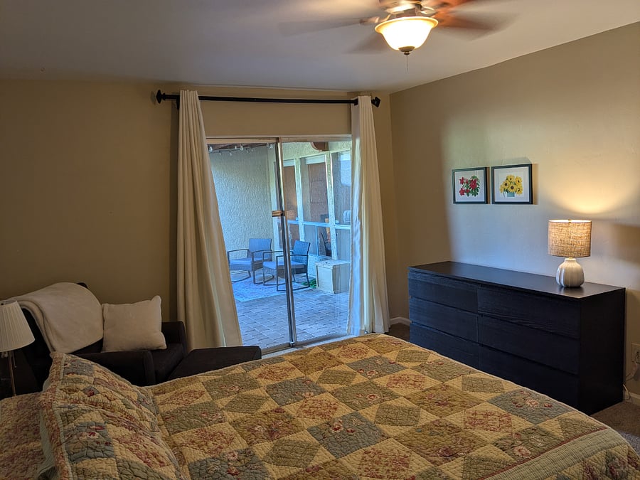 The primary bedroom has a ceiling fan, a slider into the courtyard, and a six-drawer dresser.