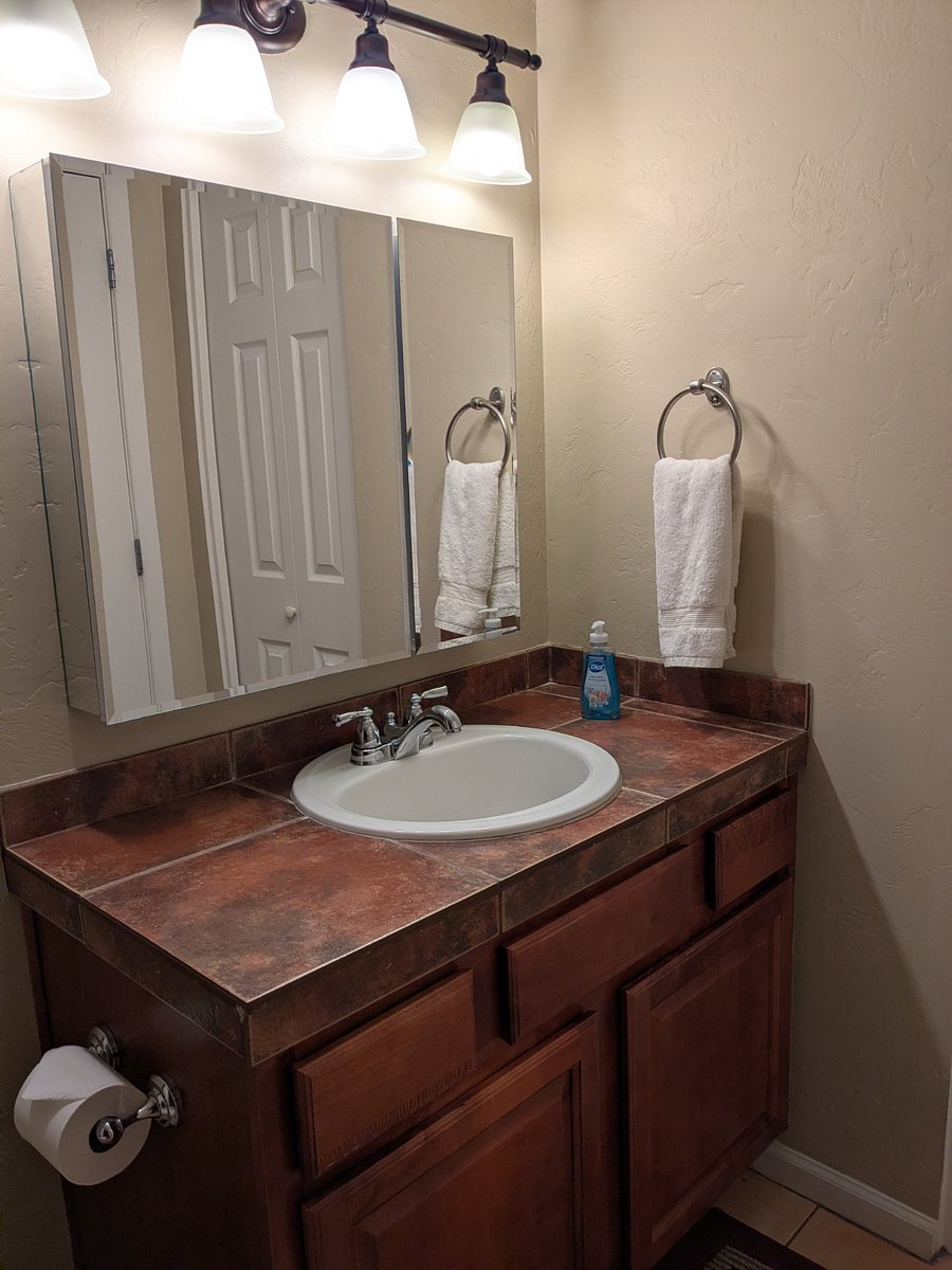 Tiled bathroom vanity. Plenty of towels are provided, including pool towels.