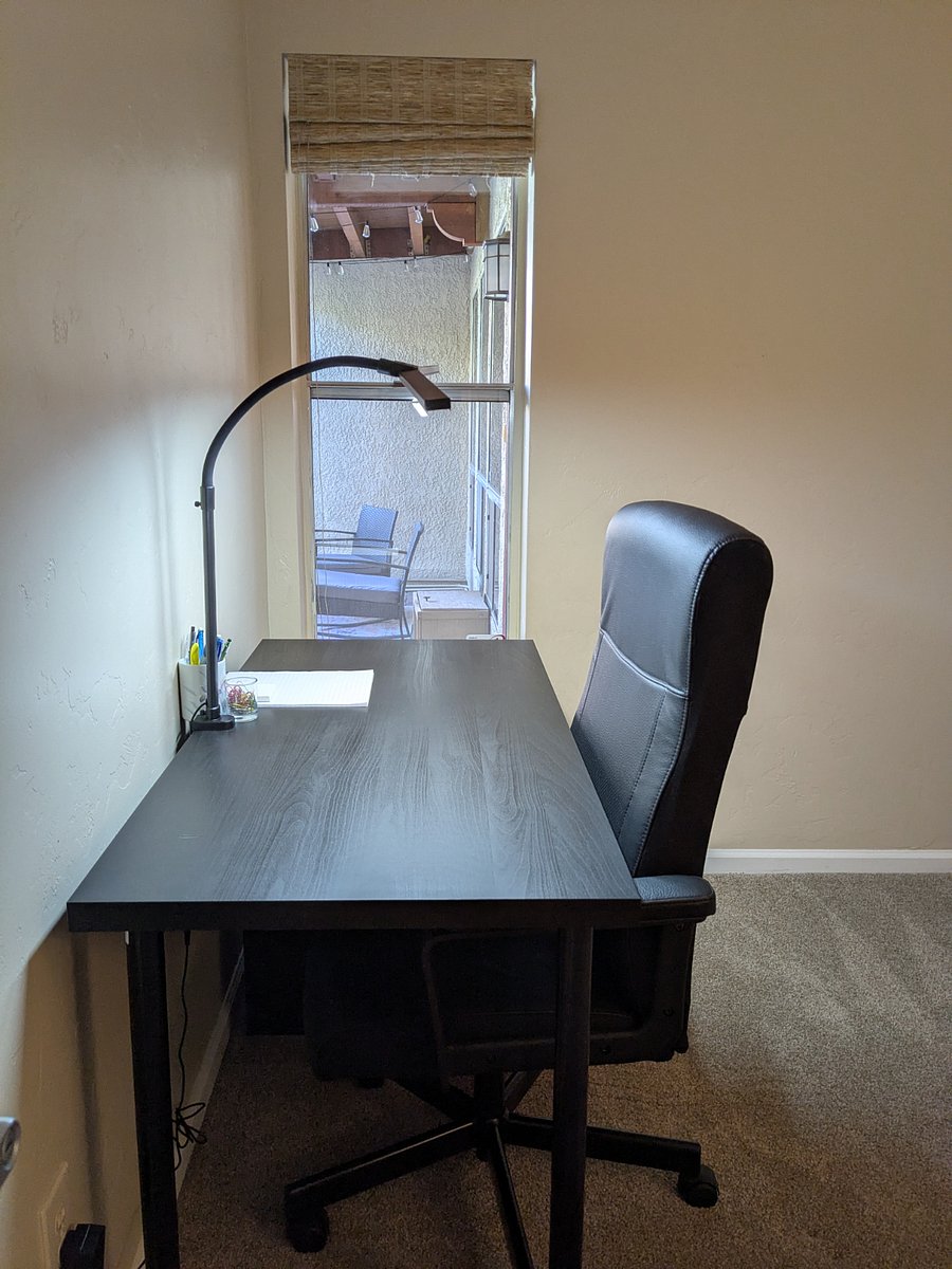 The second bedroom is furnished as a small office space. The desk has task lighting and a view into the courtyard.