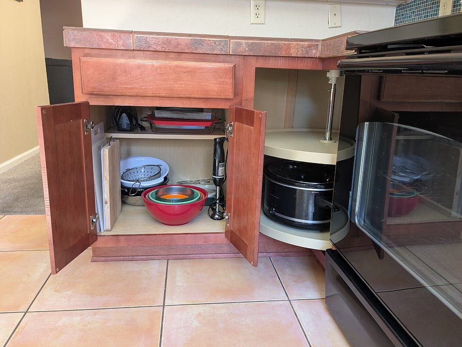 More kitchen equipment - cutting boards, mixing bowls, bakeware, and a crock pot.