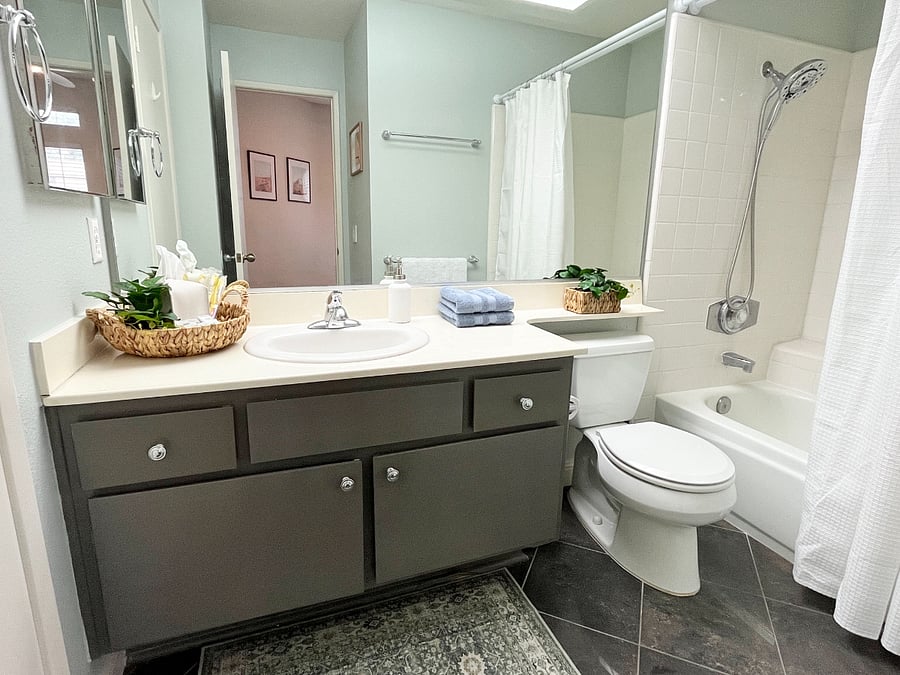 The second ensuite full bath offers dual access with doors from the bedroom and living room, featuring a full-size bath tub and a spa-like rainfall showerhead  perfect for kids and family use.