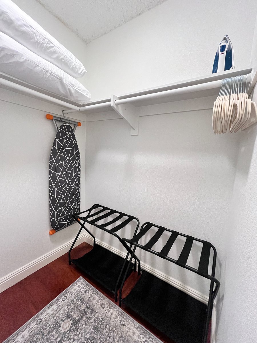 Spacious Walk-in Closet with iron, ironing board, luggage racks, velvet hangers, extra pillows, and a rolling laundry basket everything you need to stay organized and comfortable.