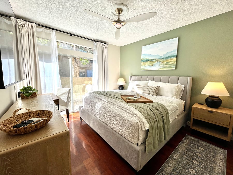 Primary Ensuite with plush king bed and luxe furnishings. Features a mirrored walk-in closet plus extra mirrored closet, 65" Smart TV, and a fully equipped workstation perfect for relaxing, working remotely, or unwinding after a day of exploring.