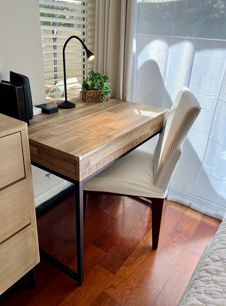 Work in comfort at the dedicated workstation, featuring a roomy desk, ample table space, desk light, convenient outlet, comfy chair, and a refreshing outdoor view.