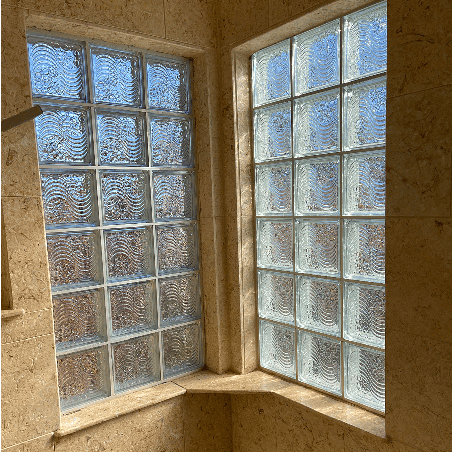 Well-lit walking sandstone tiled shower
