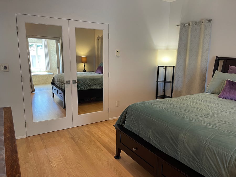 Double-sided mirror doors to large walkin closet.