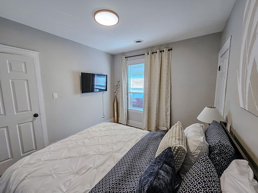 Primary bedroom with natural light and 43" smart TV.